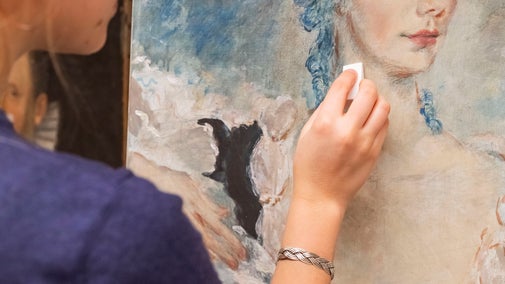 Conservator working on a portrait by Oliver Messel